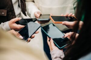 close,view,of,young,people,hands,holding,mobile,phones,in