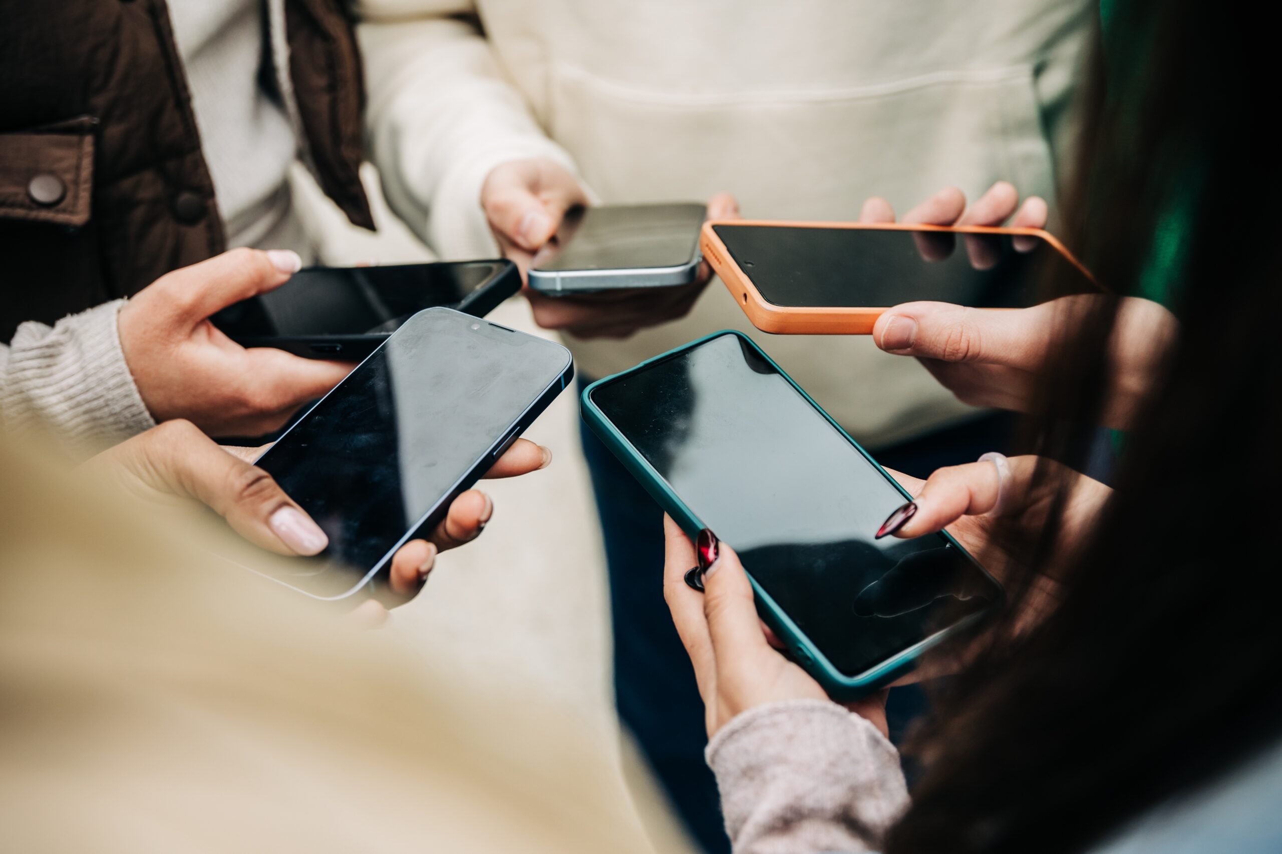 close,view,of,young,people,hands,holding,mobile,phones,in